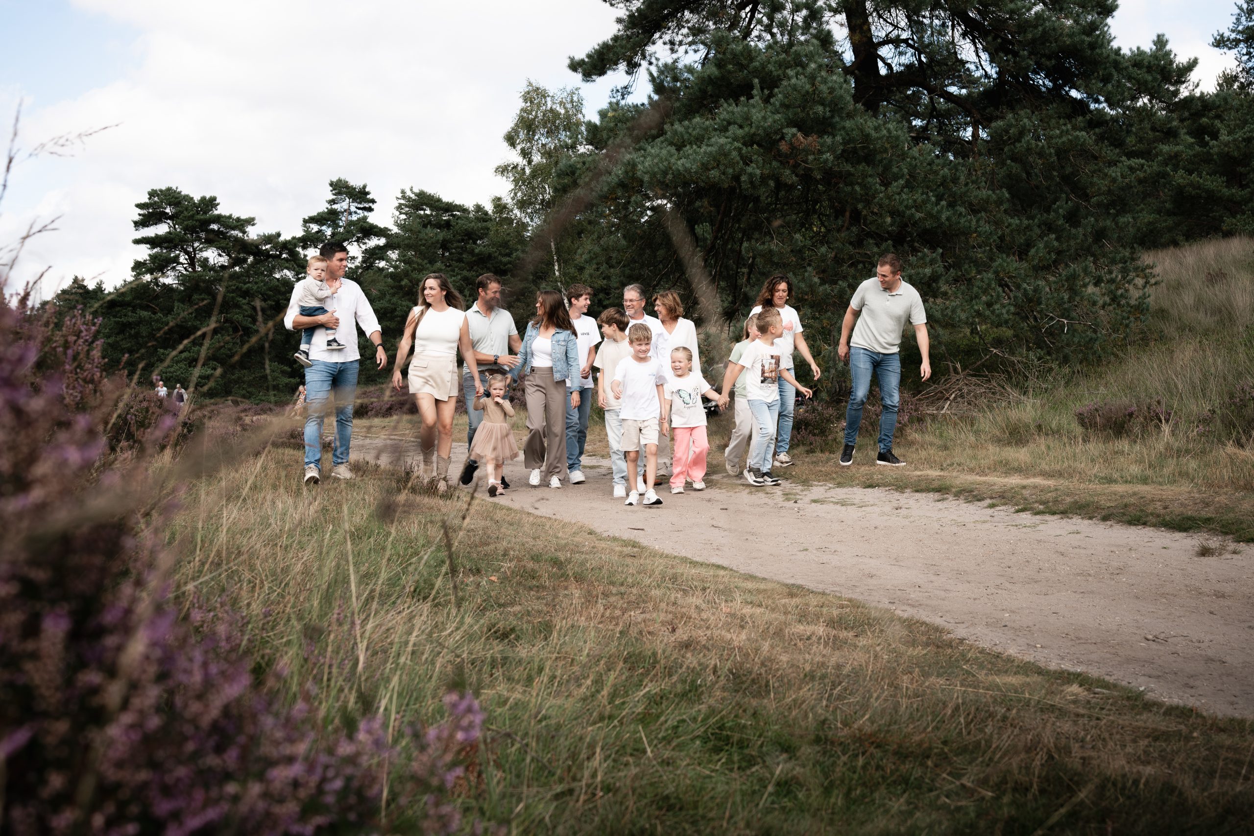 Grote familie met kinderen, ouders en grootouders tijdens een ontspannen familieshoot in de natuur in Twello of Apeldoorn.