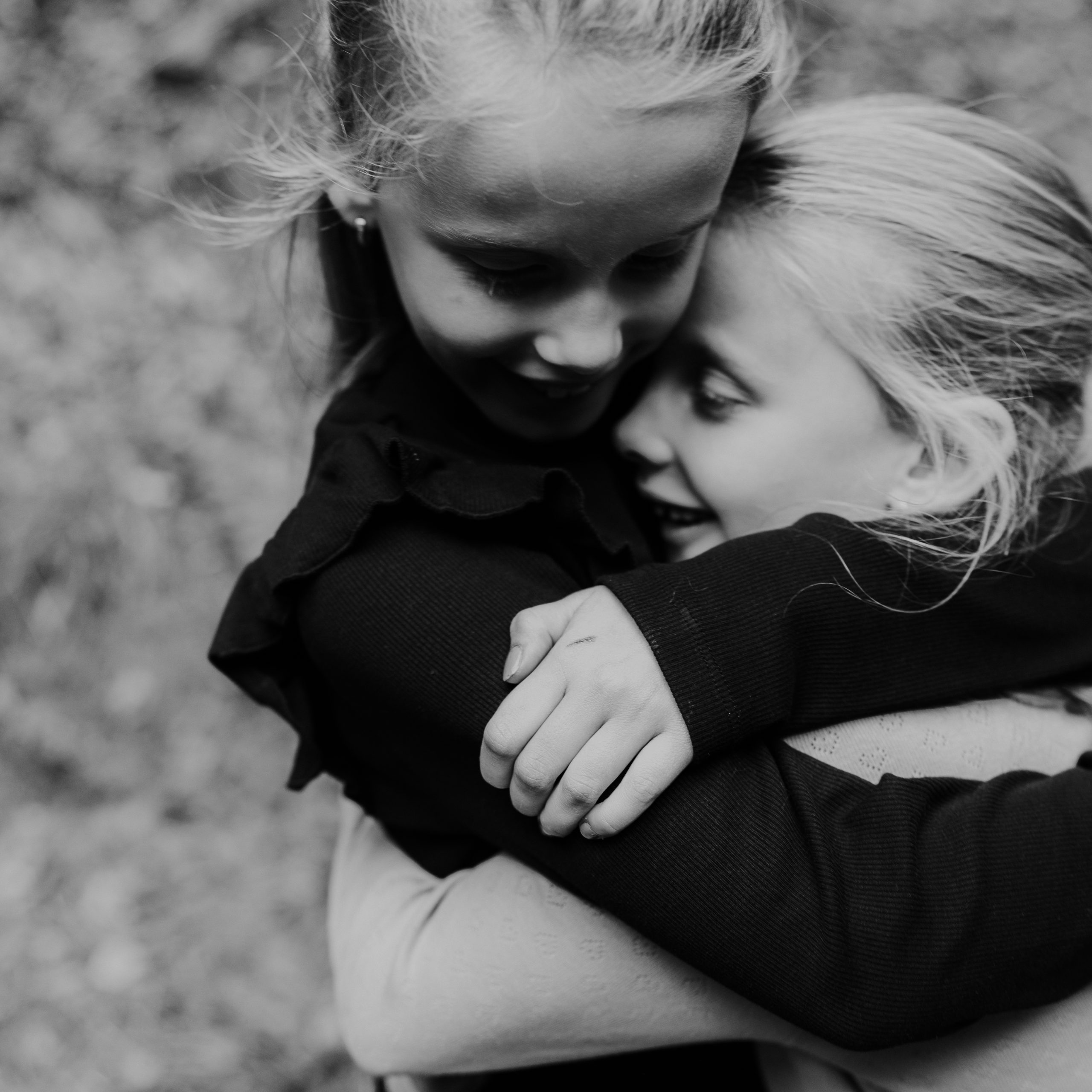 Marije Gerritsen Fotografie - Gezinsshoot website-7 Gezin met twee dochters tijdens een ontspannen gezinsfotoshoot in de natuur in Twello of Apeldoorn, spelend en knuffelend.