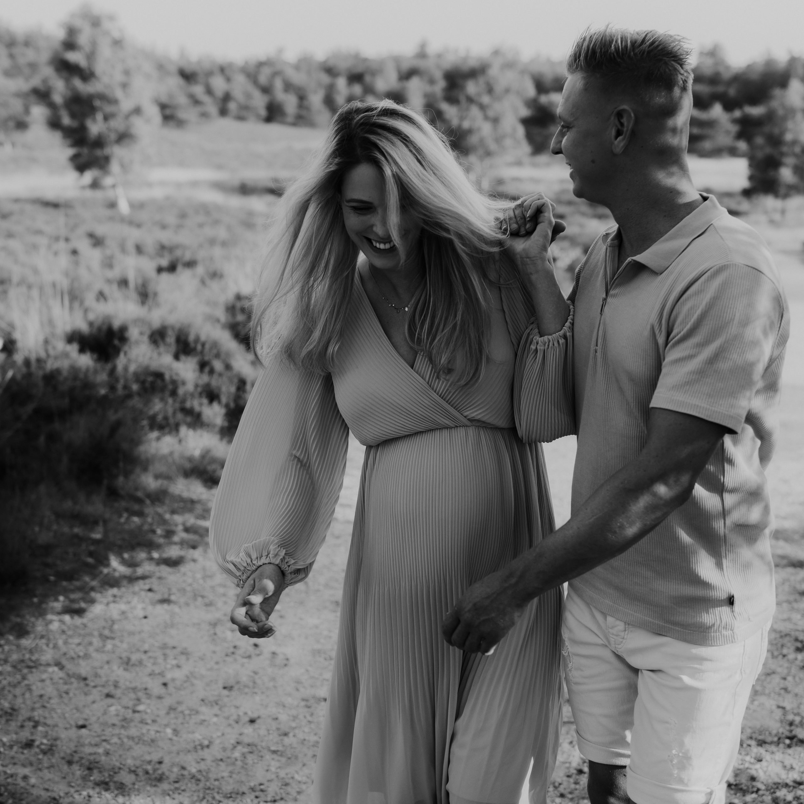 Marije Gerritsen Fotografie - Zwangerschapsshoot website-1 Aanstaande ouders tijdens een ontspannen zwangerschapsshoot in de natuur, met focus op details zoals handen op de buik.